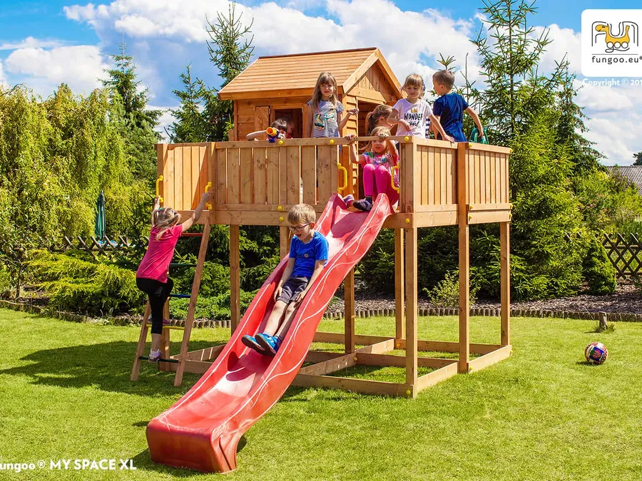Kinder spielen an einem Fungoo-Spielturm mit Rutsche im Garten